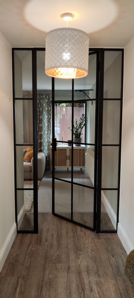 corridor with crittall style doors and a chandelier