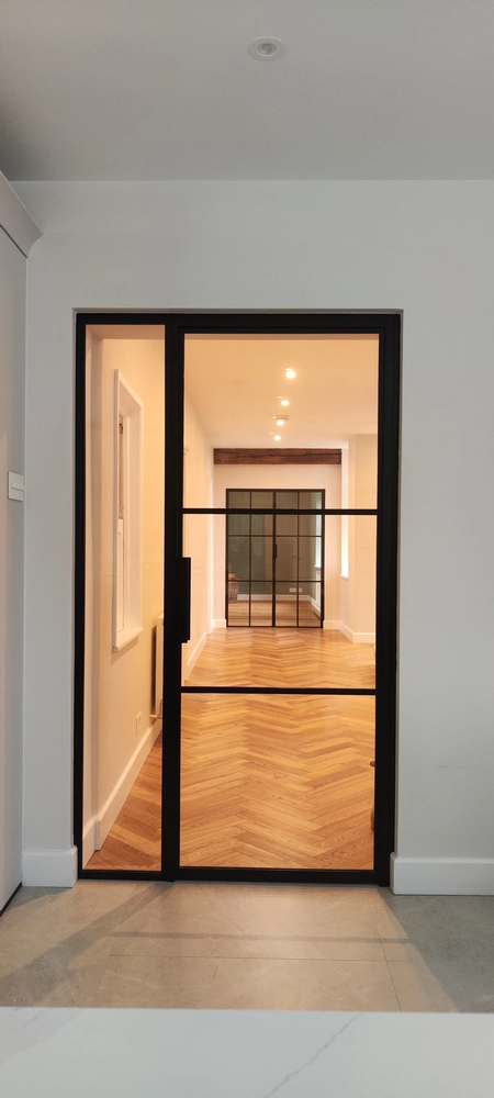 hallway with internal crittall doors and chevron wood flooring