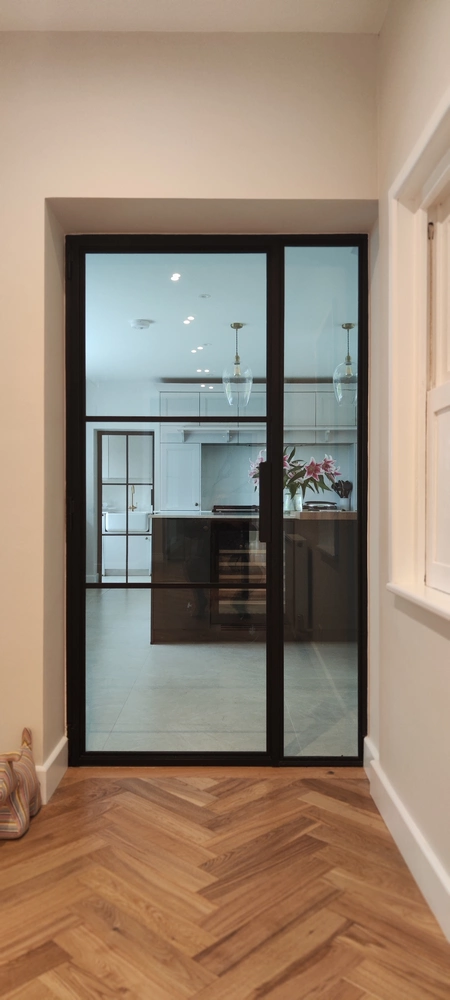 kitchen with steel crittall doors and a view to the dining area