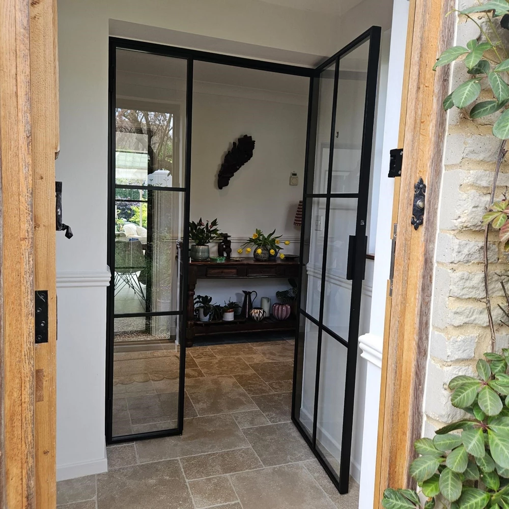 pantry entrance with crittall bifold doors and rustic stone wall