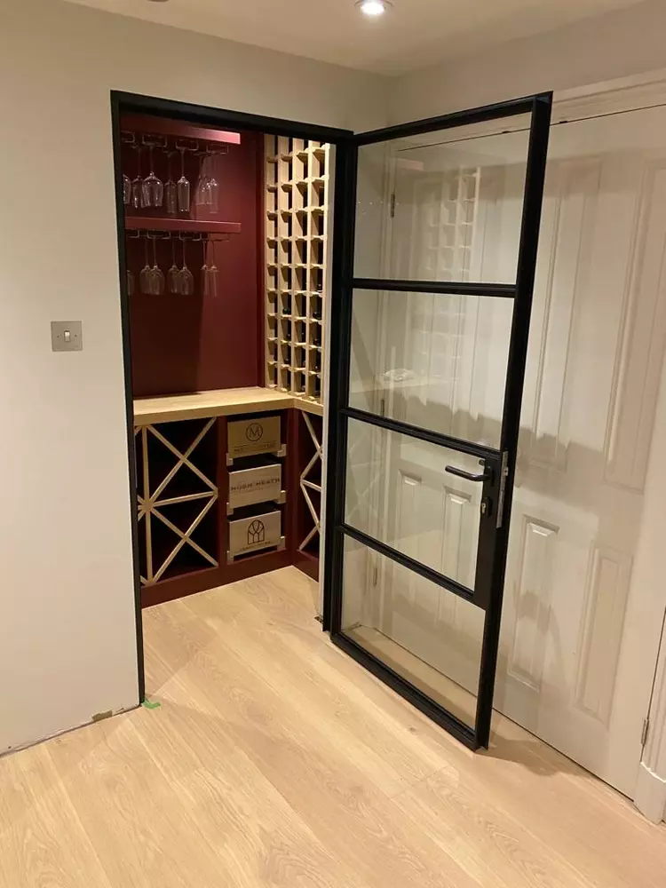wine cellar entrance with black steel doors and glass panels