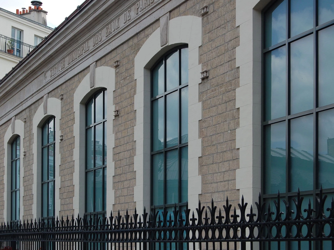 historic facade with arched steel windows and doors and stone details