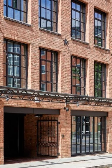 historic red brick building with external crittall doors and classic details