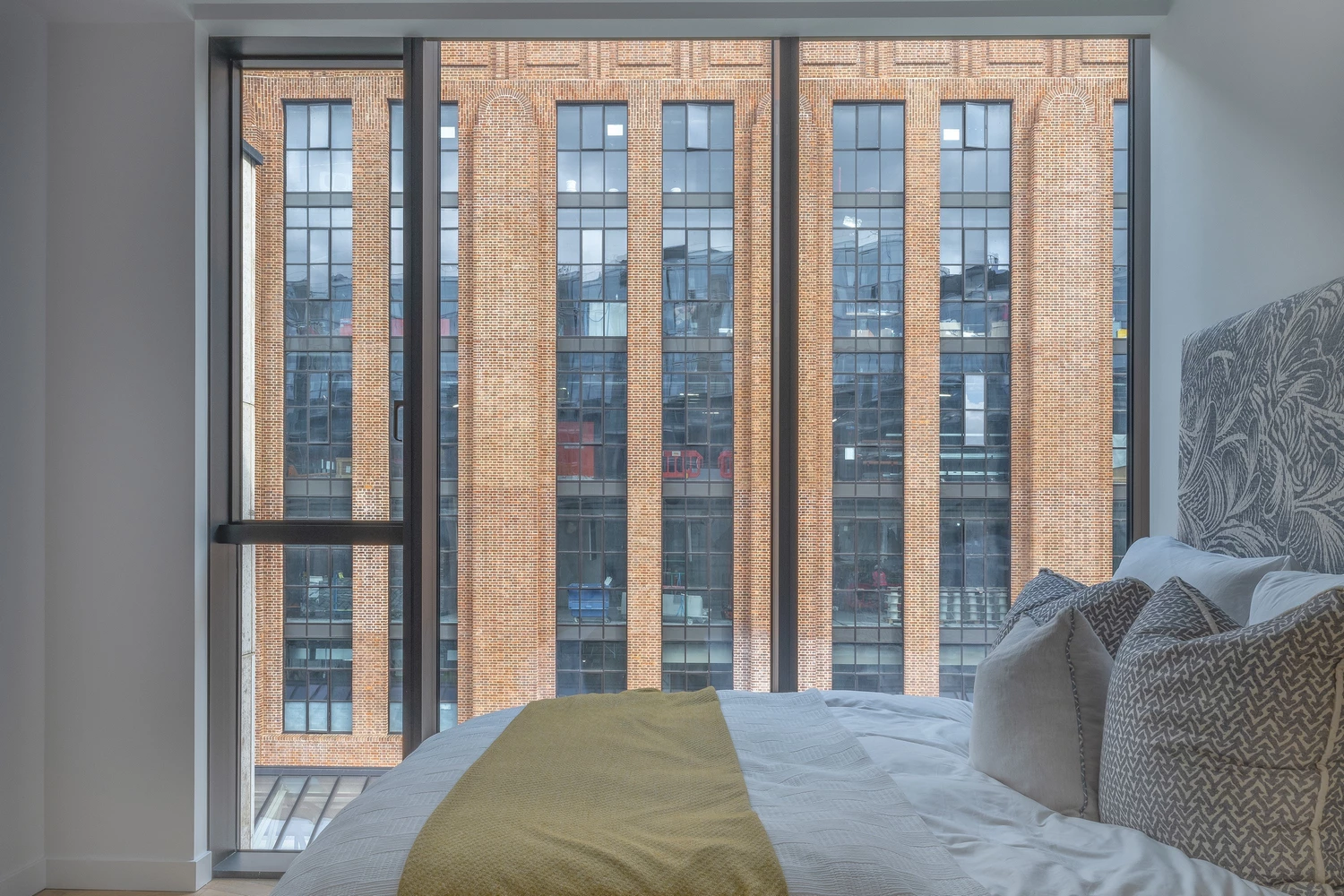 bedroom with floor-to-ceiling metal windows and doors and city view