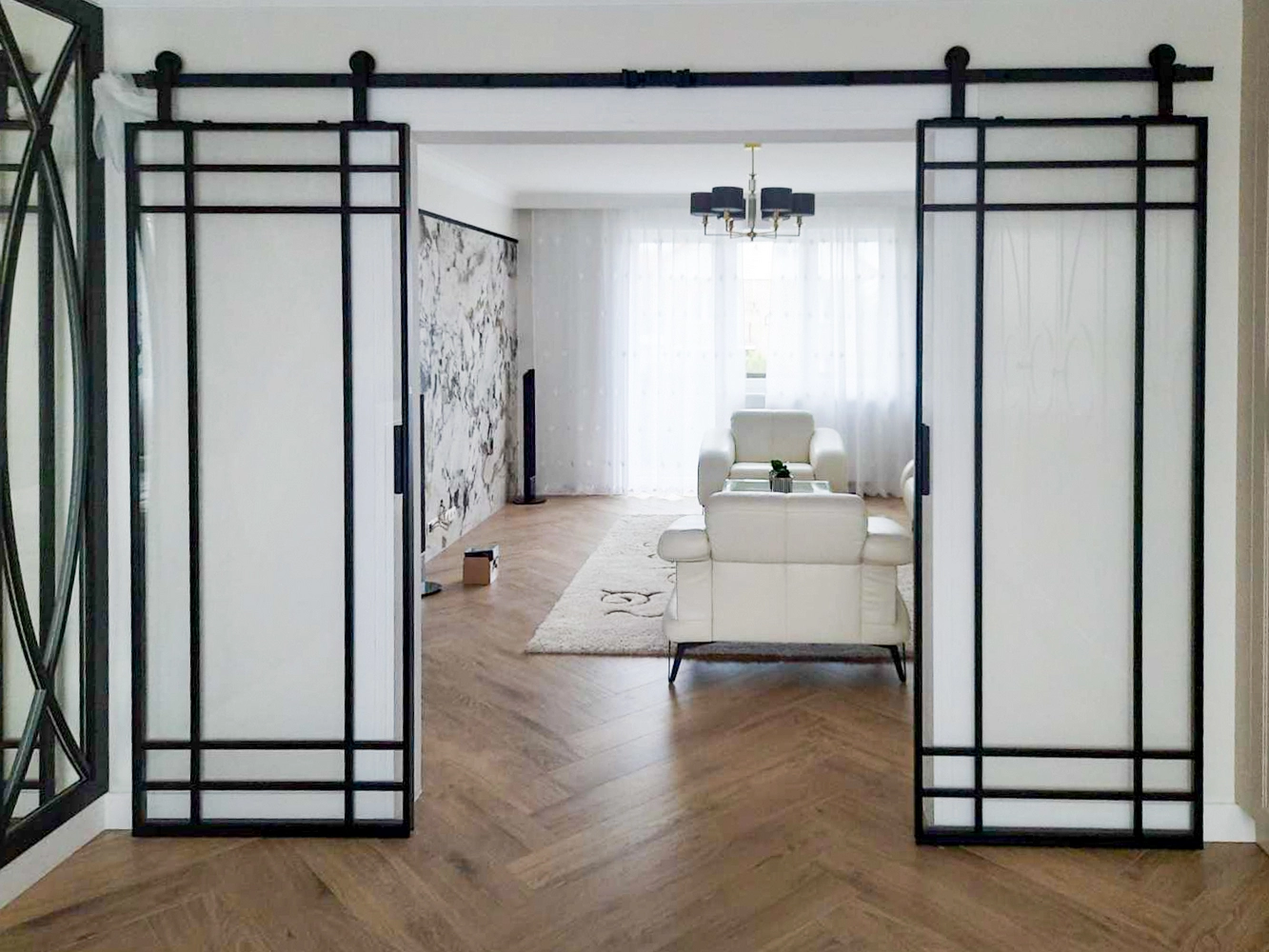 open-plan space with sliding crittall style doors and chevron wood flooring