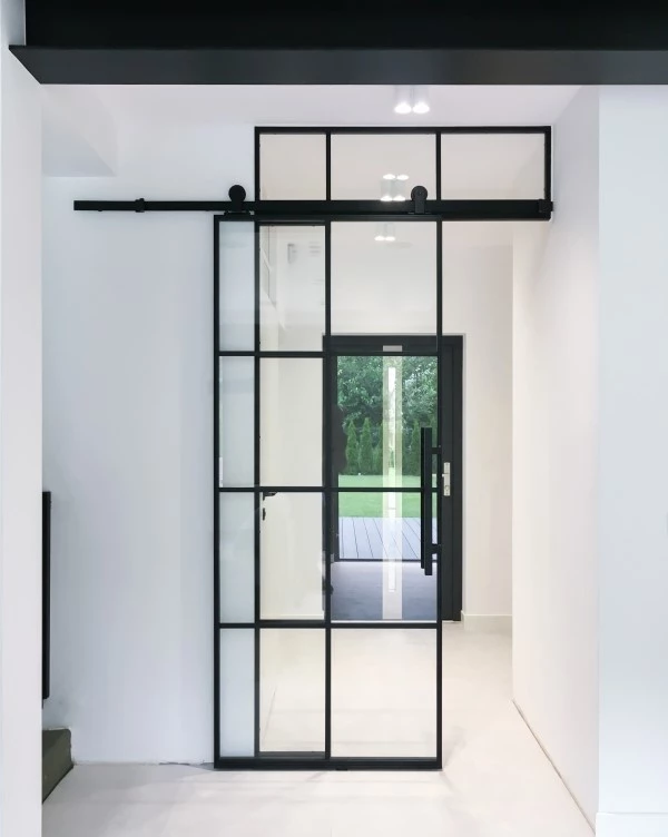 entryway with black steel doors and minimalist white decor