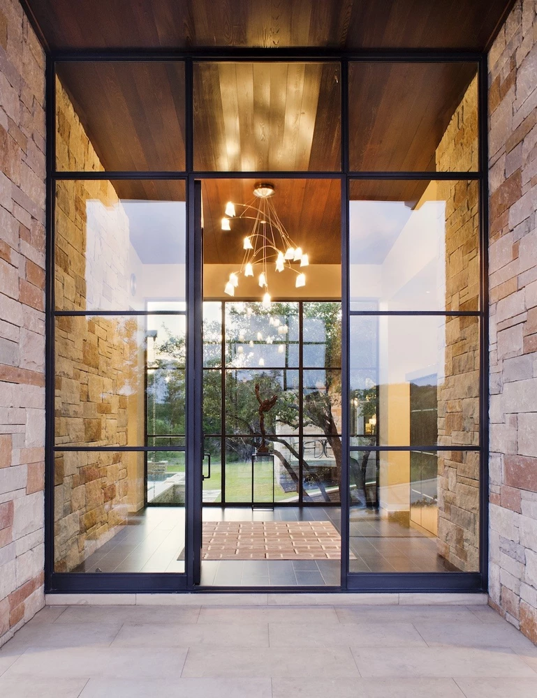 patio entrance featuring external crittall doors and stone wall accents