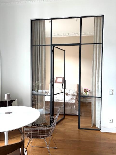 Interior french doors separating living room and bedroom in apartment